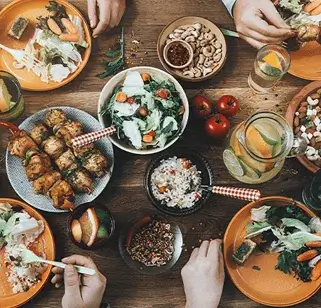 Flat lay of rustic wood dining table with several plates of food